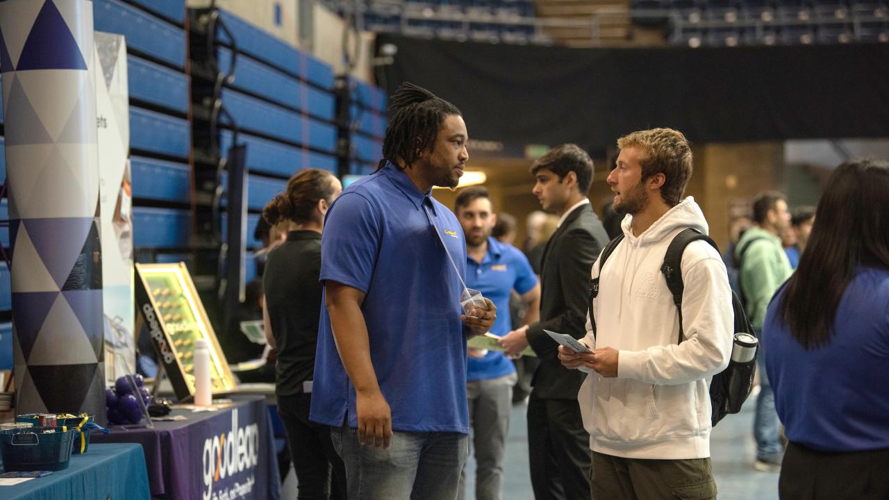 A student speaks with a potential employer at the career fair