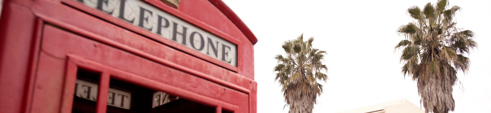 Red telephone booth with red double decker bus in background