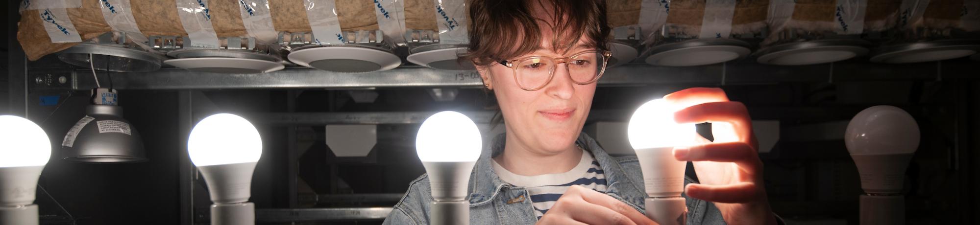 Student installing LED bulbs