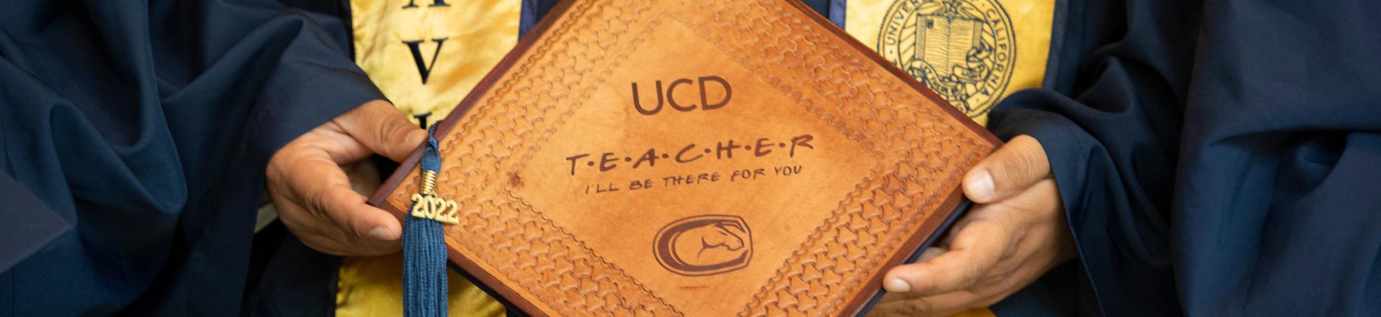 Close up of mortar board with UC Davis Teacher written on it.